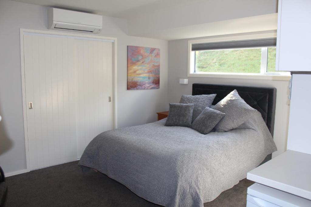 1 dormitorio con cama y ventana en Blue Skies Guest Accommodation, en Queenstown