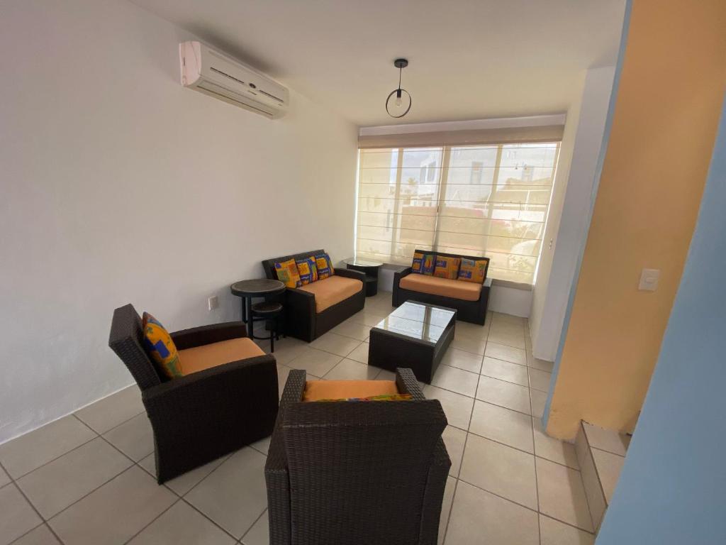a living room with couches and chairs and a window at Tropical Home in excellent location just 10 min from Nuevo Vallarta Beach in Mezcales