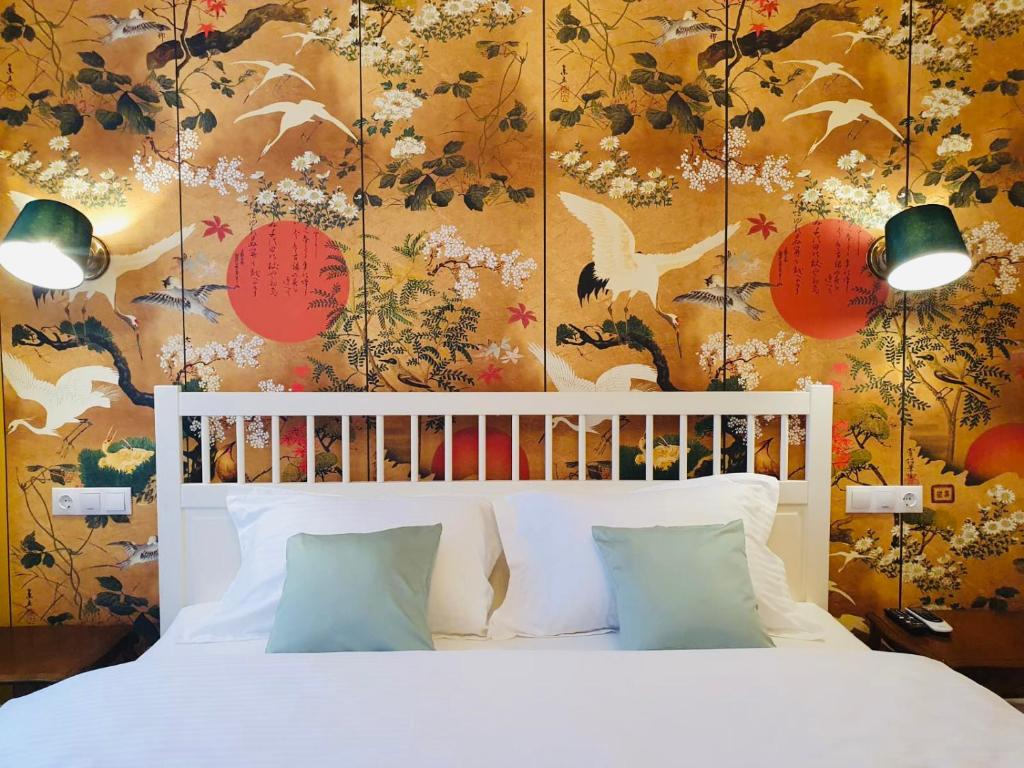- une chambre avec un lit blanc et un papier peint floral dans l'établissement Filip Apartment Oradea, à Oradea