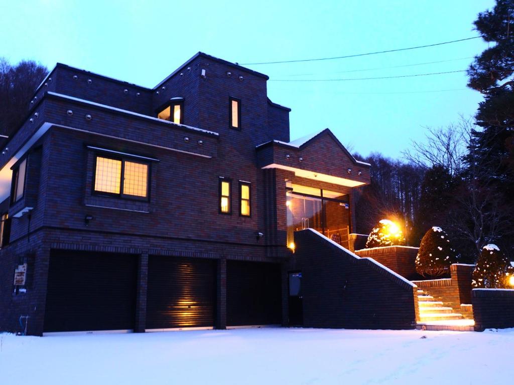 una casa grande con nieve delante en Senougen en Sapporo
