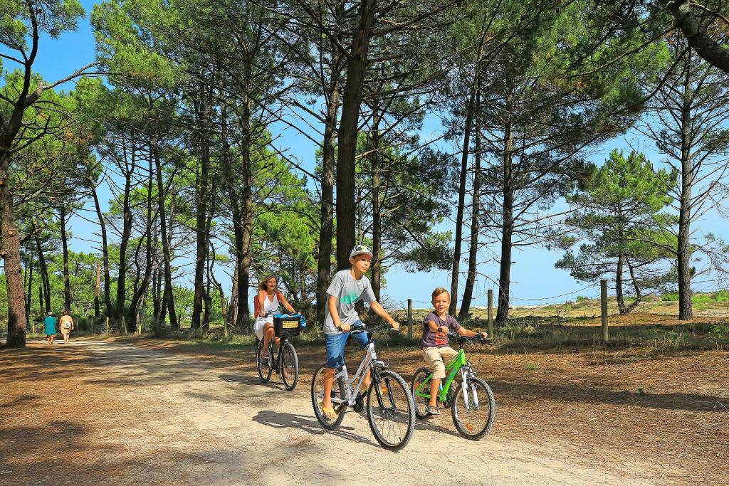 a man and a woman riding bikes with a child at Camping Campéole Le Vivier - Maeva in Biscarrosse