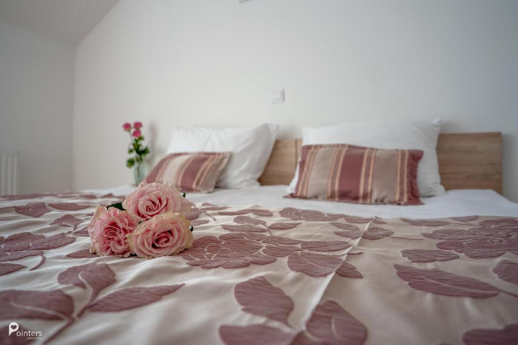 two pink roses sitting on top of a bed at Hotel Amarilis in Netretić
