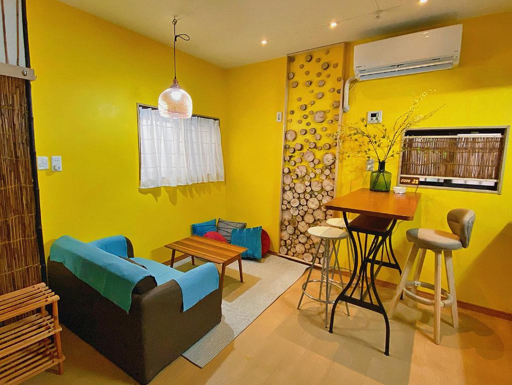 uma sala de estar amarela com um sofá e uma mesa em Lucy's House横浜中華街 House5 em Yokohama