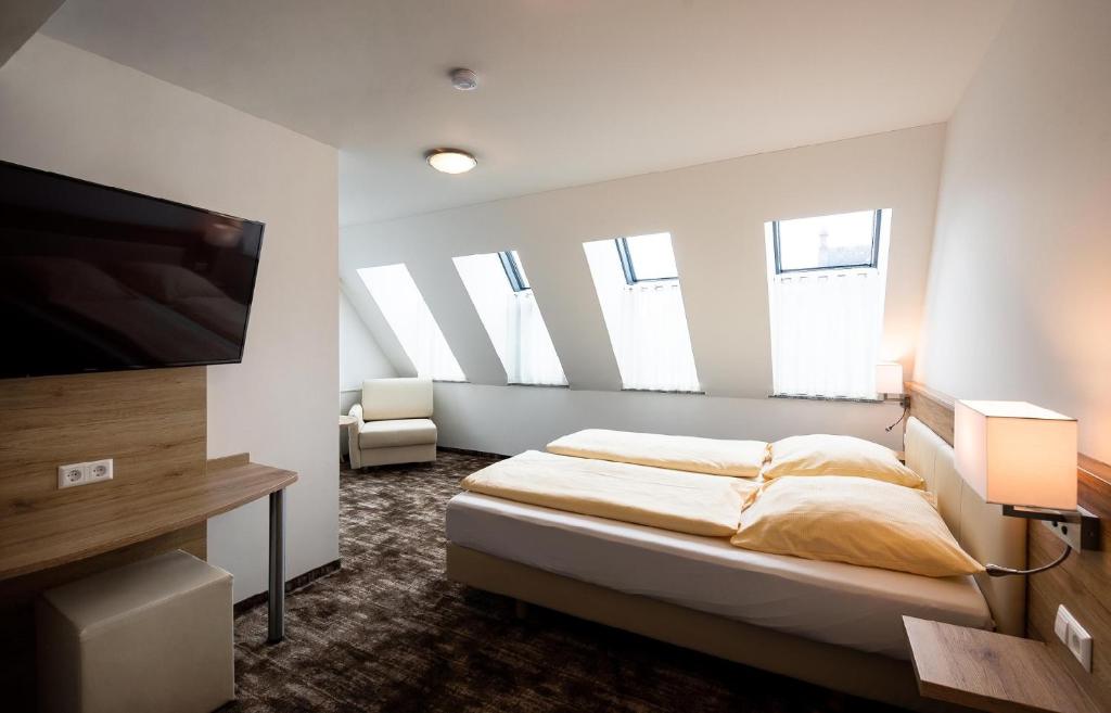 
a hotel room with a bed and a tv at Sternplatz-Hotel in Ehingen
