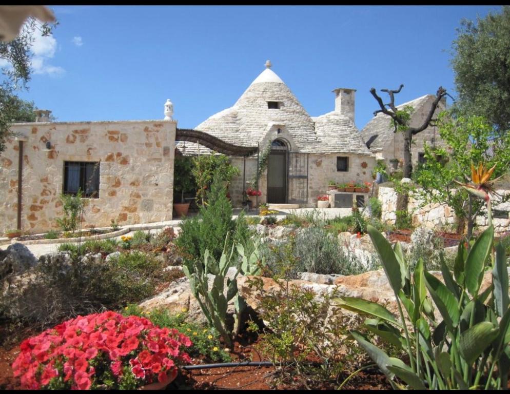 a garden in front of a stone house at Spacious Villa with Private Pool in Castellana Grotte in Alberobello