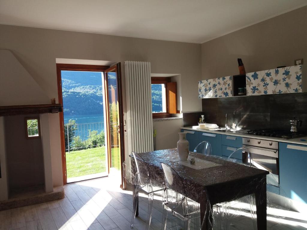 a kitchen with a table and a view of a mountain at Lago d'Orta Appartamento con vista in Pettenasco