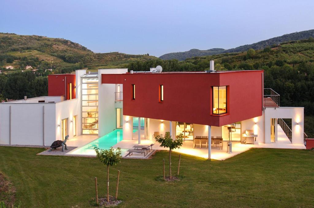 a large house with a red at Villa de 4 chambres avec piscine privee jacuzzi et jardin amenage a Saint Desirat in Saint-Désirat