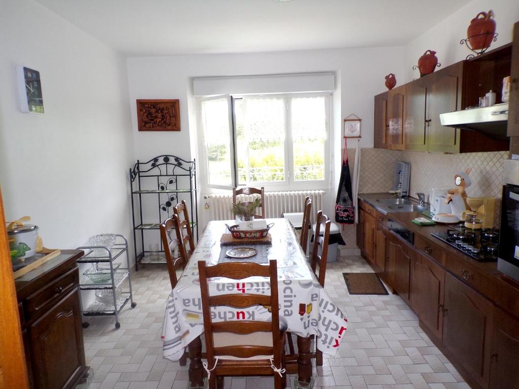 a kitchen with a table and chairs in it at Appartement de 3 chambres avec jardin clos et wifi a Toulonjac in Toulonjac