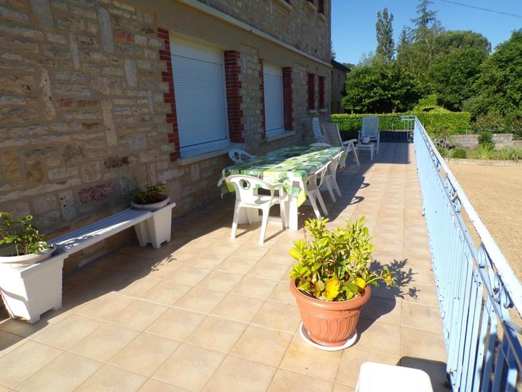 a patio with a table and chairs on a balcony at Appartement de 3 chambres avec jardin clos et wifi a Toulonjac in Toulonjac