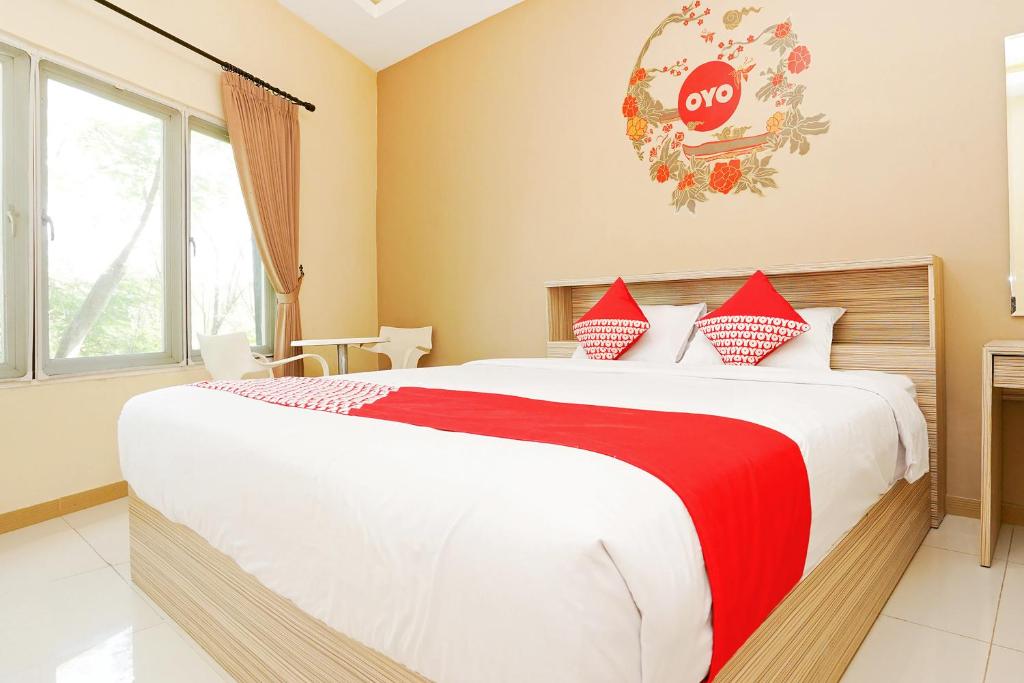 1 dormitorio con 1 cama grande y una señal de stop en la pared en Capital O 175 K-60 Residence, en Surabaya