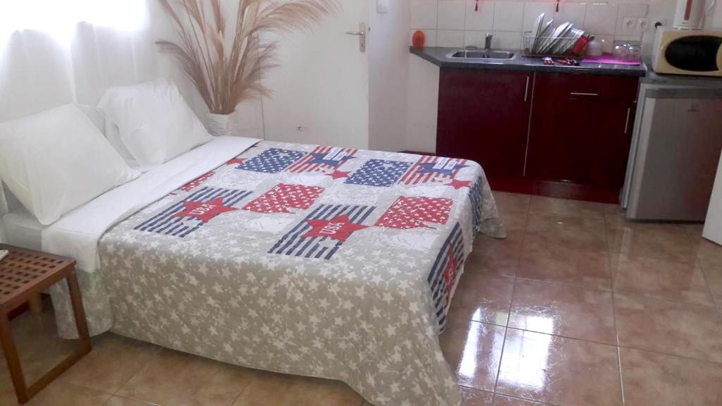 a bedroom with a bed with a patriotic quilt on it at Bungalow de 2 chambres avec piscine partagee jacuzzi et terrasse amenagee a Le Gosier a 5 km de la plage in Le Gosier