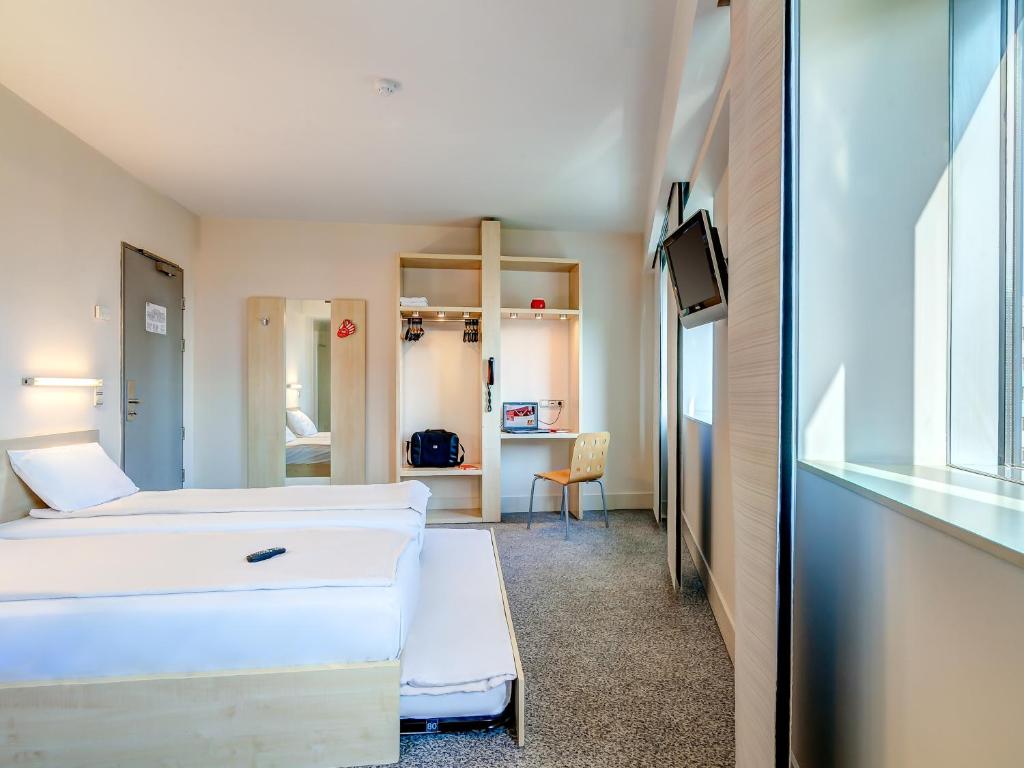 Pokój szpitalny z dwoma łóżkami i telewizorem w obiekcie Hello Hotels Gara de Nord w Bukareszcie