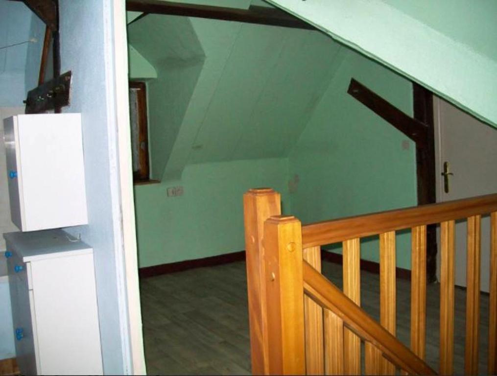 Zimmer mit einem Holzgeländer und einer Treppe in der Unterkunft Maison de 3 chambres avec jardin amenage et wifi a Reffuveille in Reffuveille