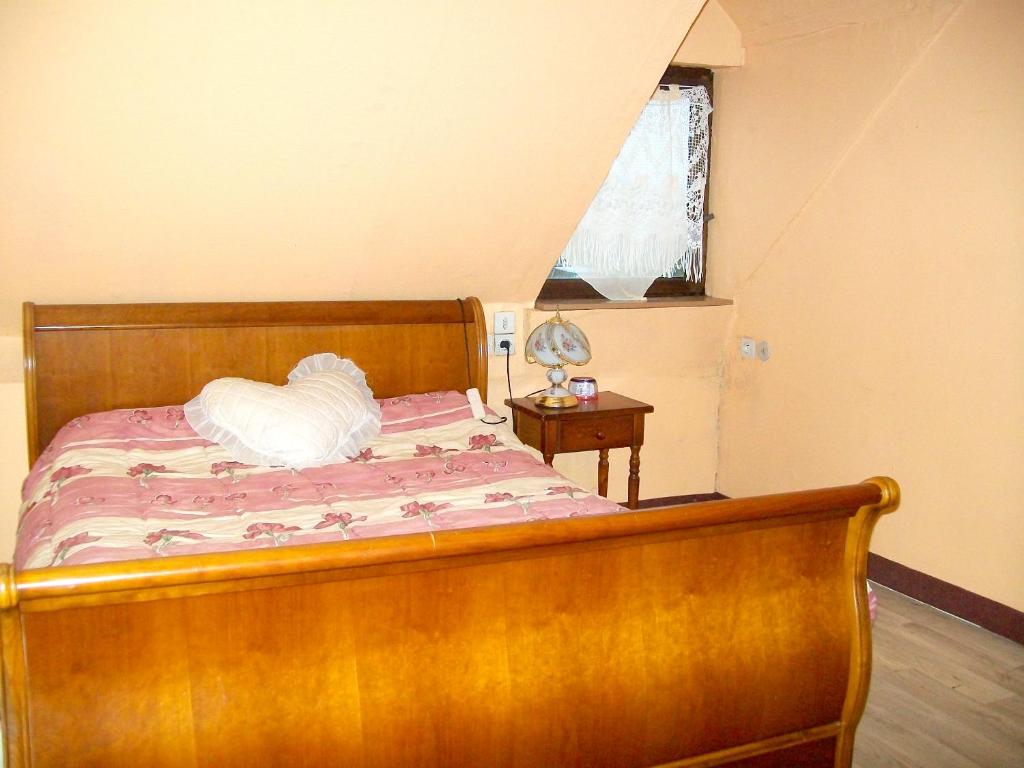 Schlafzimmer mit einem Bett mit einem Holzrahmen und einem Fenster in der Unterkunft Maison de 3 chambres avec jardin amenage et wifi a Reffuveille in Reffuveille