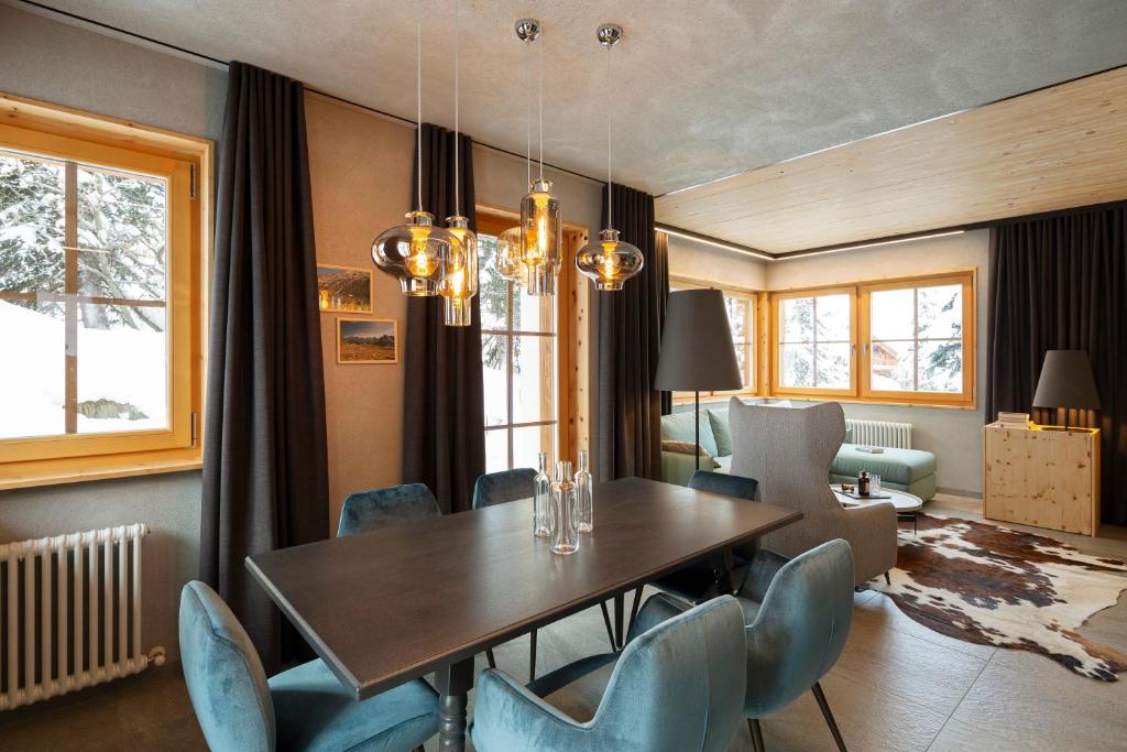 a dining room with a table and blue chairs at Chalet Cirmolo in Livigno