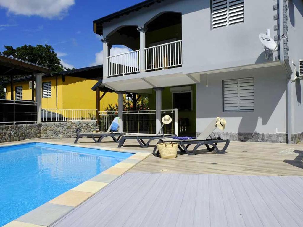 a house with a swimming pool next to a building at Appartement charmant à Lamentin avec piscine in Lamentin