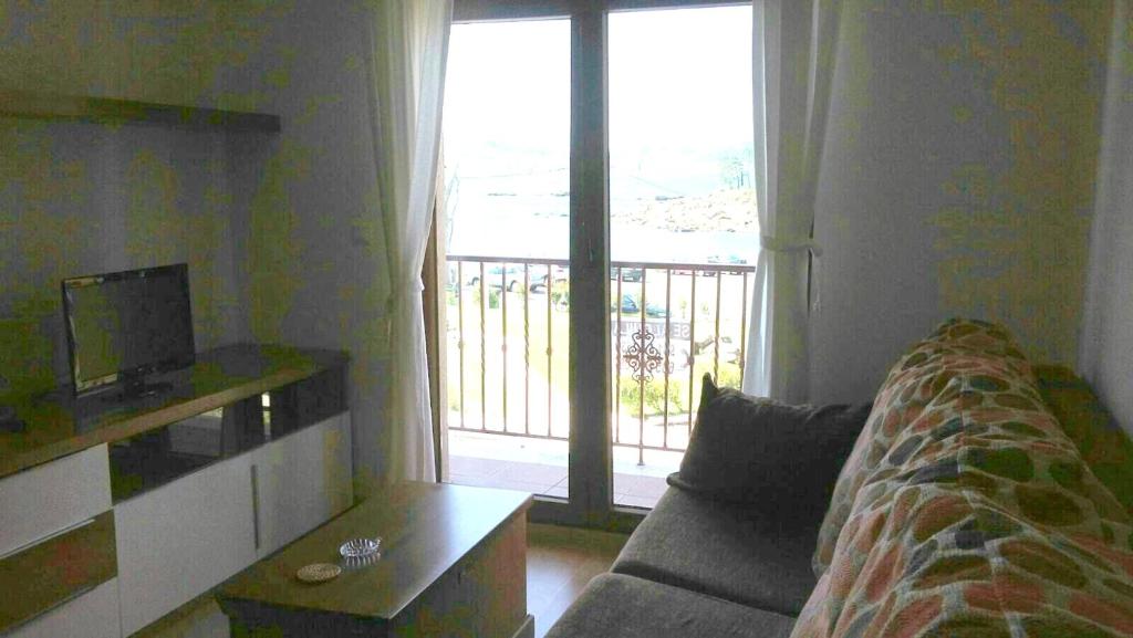 Una sala de estar con un sofá y una puerta corrediza de vidrio. en Contemporary Apartment in Riveira + Sea View, en Ribeira