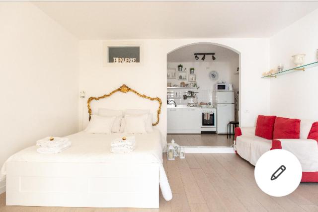 Cosy Home Napoli في نابولي: غرفة نوم بيضاء مع سرير أبيض وأريكة حمراء
