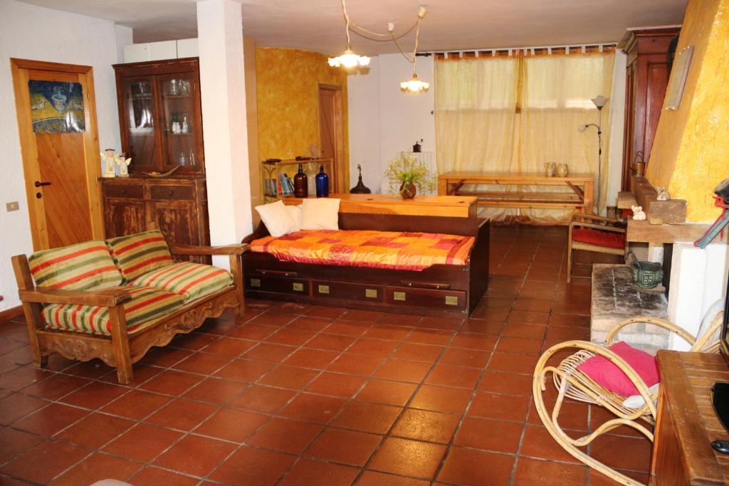salon z łóżkiem i krzesłem w obiekcie Charming House near Monteciccardo with Private Pool w mieście Monteciccardo