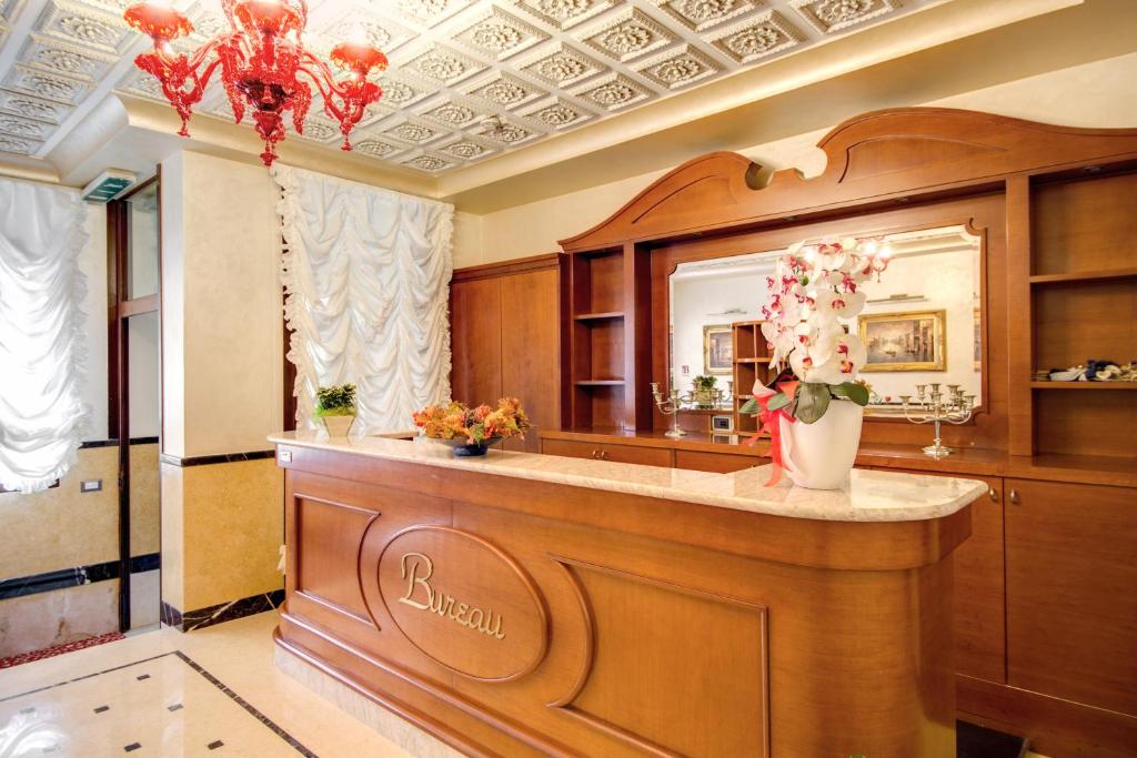 a bathroom with a vanity with a mirror and flowers at Domus Cavanis in Venice