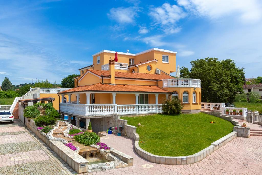 a large yellow house with a lawn in front of it at Villa Marko in Medulin