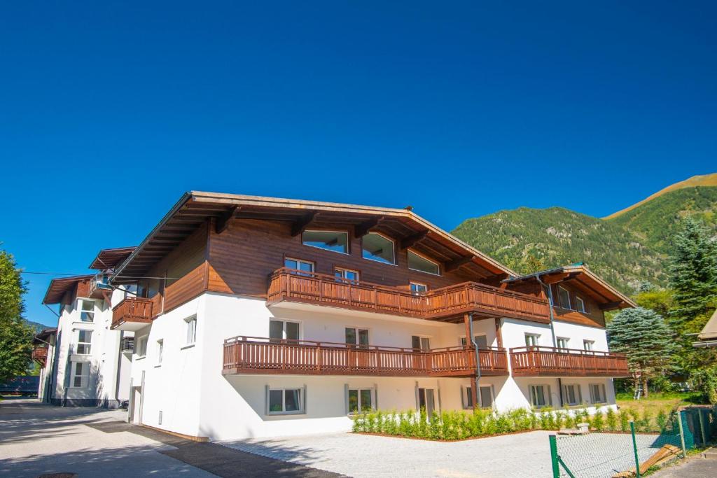 a large apartment building with a wooden roof at Haus Breitenfellner by AlpenTravel in Bad Hofgastein
