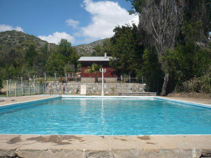 une grande piscine bleue en face d'une maison dans l'établissement El Parador de Caleu, à Tiltil