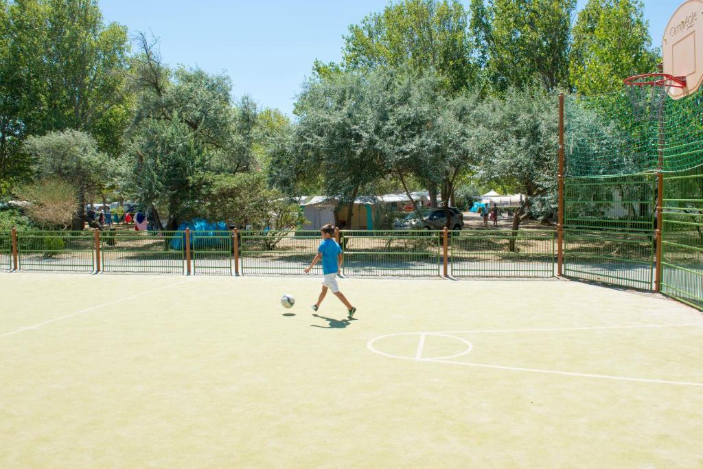a person playing with a soccer ball on a court at Camping Campéole La Côte des Roses - Maeva in Narbonne