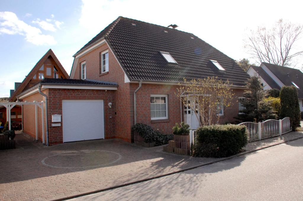 a brown brick house with a white garage at Trassenheide Strandgalopp am Walde Wohnung W1TE in Trassenheide