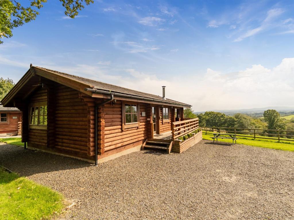 a log cabin with a picnic table in front of it at Bluebells in Beaworthy