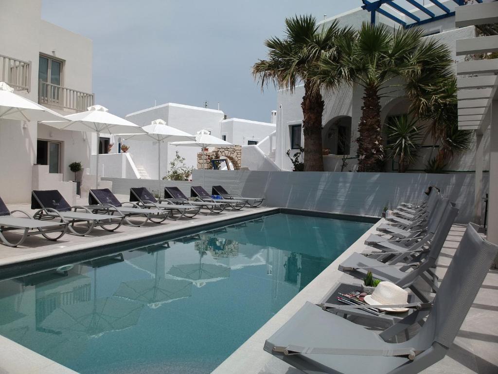 a swimming pool with lounge chairs next to a building at Angels Pillow Luxury Boutique Residence - Adults Only in Naousa