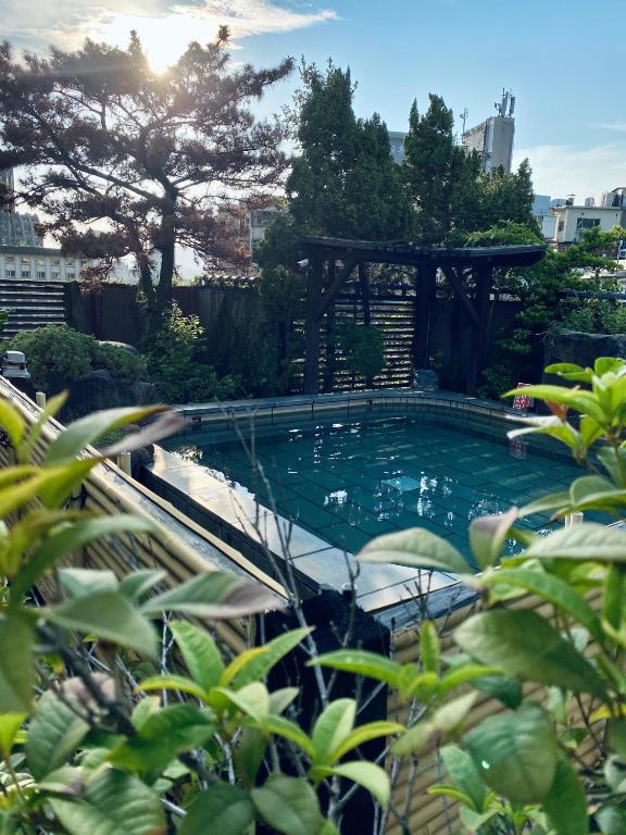 a swimming pool with a gazebo in a garden at Spa Spring Resort in Taipei