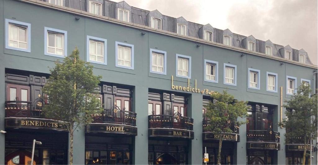 een groot blauw gebouw met bomen ervoor bij Benedicts Hotel in Belfast