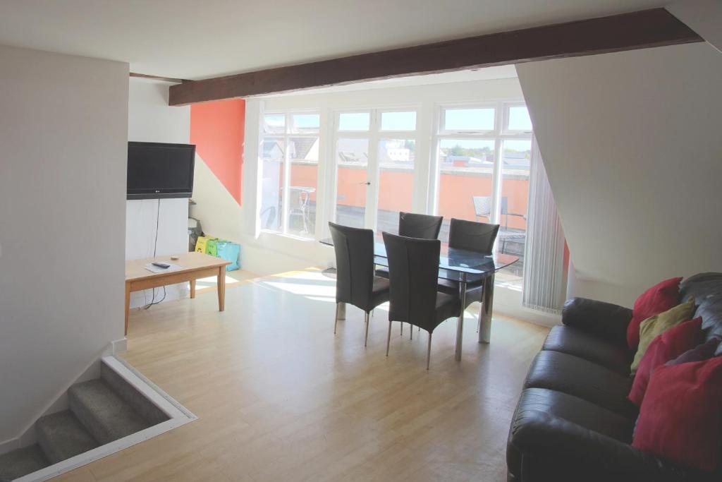 un soggiorno con tavolo, sedie e divano di Stunning Central Exeter Apartment with balcony and fantastic view a Exeter