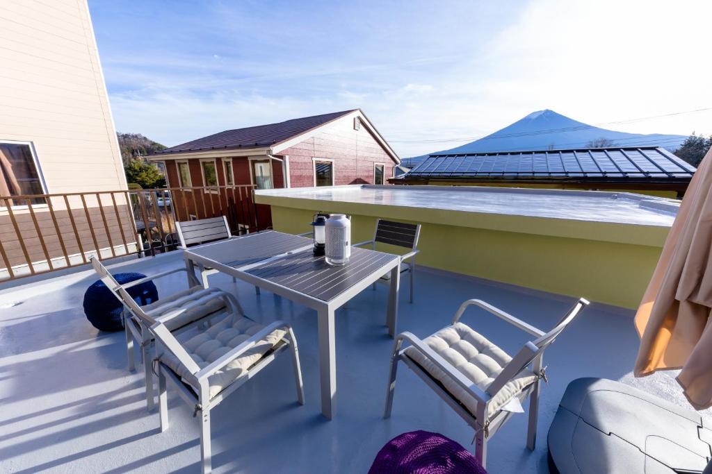 un patio avec une table et des chaises sur un toit dans l'établissement Villa RAKUWA Bettei, à Fujikawaguchiko