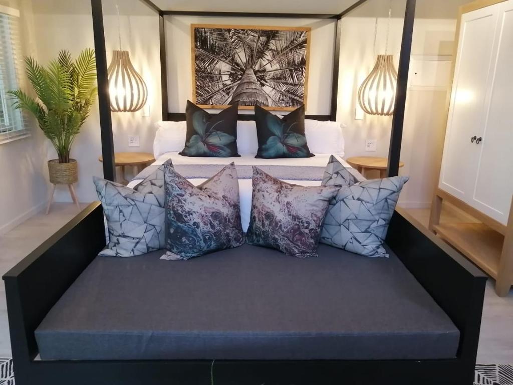 un letto in una stanza con cuscini sopra di Tranquility Lodge a Natureʼs Valley
