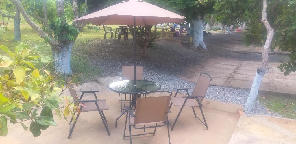 uma mesa e cadeiras com um guarda-sol num pátio em Pousada Sao Lourenco em Ubajara