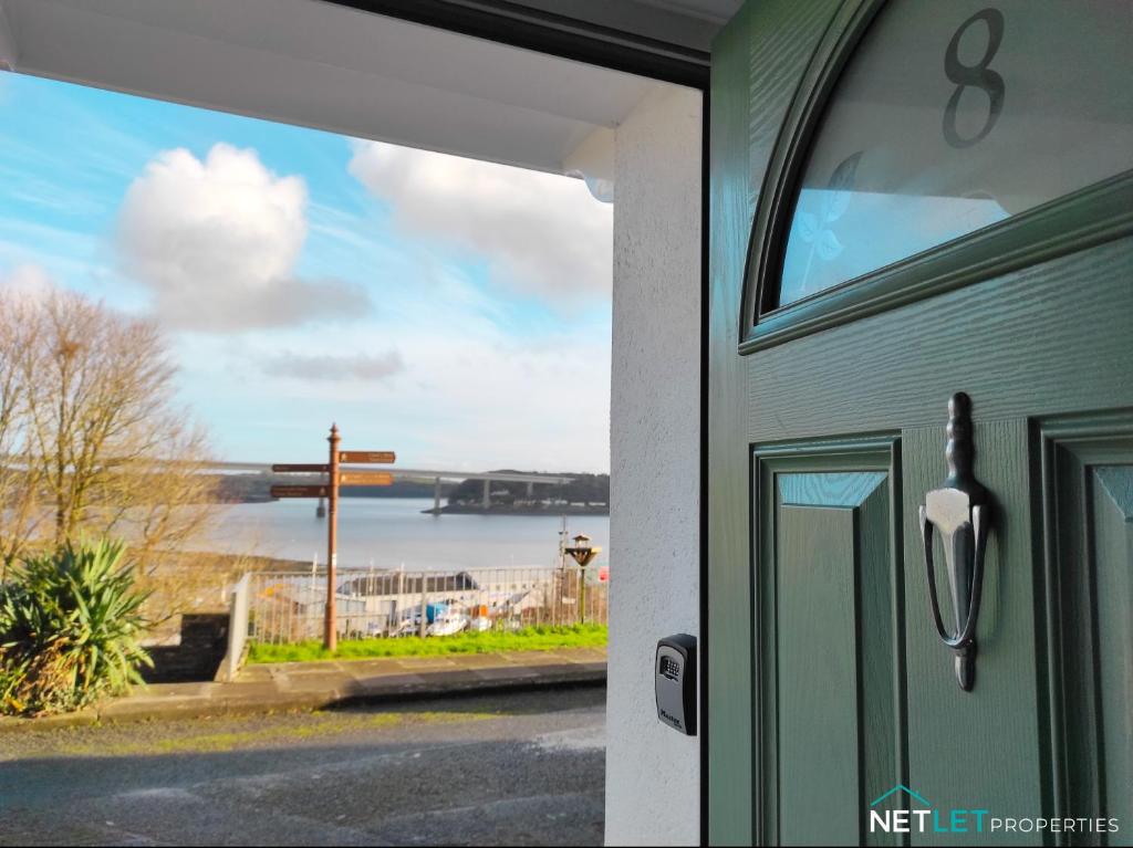 una puerta a una casa con vistas al océano en Station Cottage, en Neyland