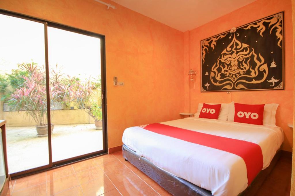 - une chambre avec un grand lit et une grande fenêtre dans l'établissement Ban Elephant Blanc Apartment, à Kata Beach
