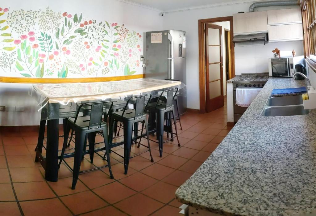 a kitchen with a bar with stools and a counter top at Hostel Sauce in Mar del Plata