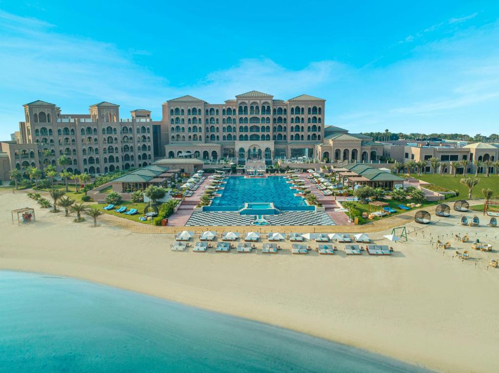 uma vista aérea de um resort com piscina e praia em Royal Saray Resort em Manama