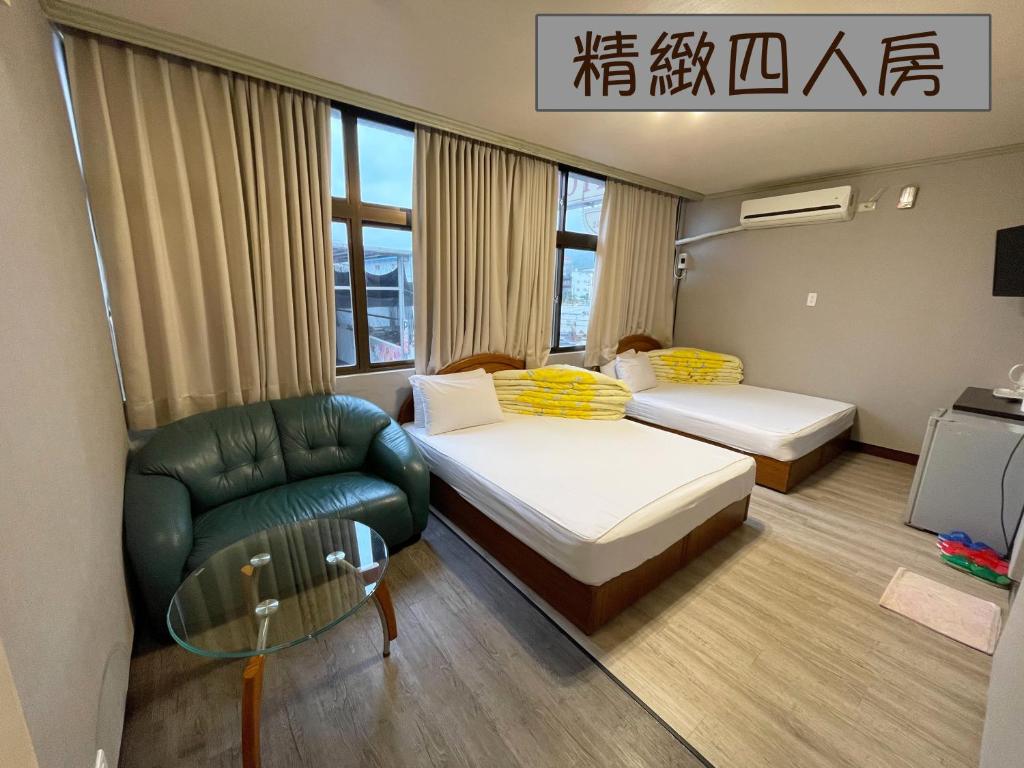 ein Hotelzimmer mit 2 Betten und einem Stuhl in der Unterkunft Yi Mei Hotel in Jinshan