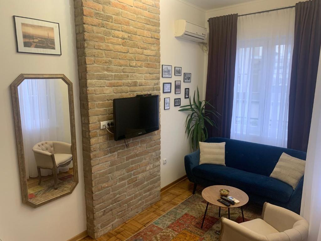 a living room with a blue couch and a mirror at Old Town City Center in Belgrade