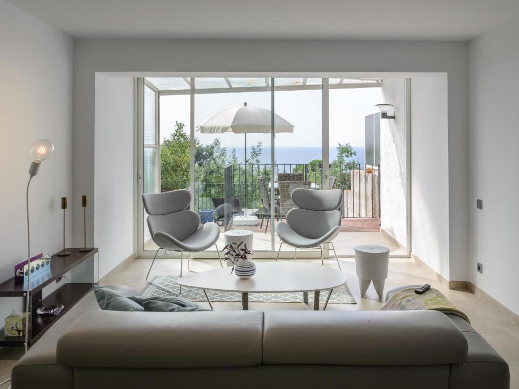 sala de estar con sofá, sillas y mesa en Danlux alba, en Tossa de Mar