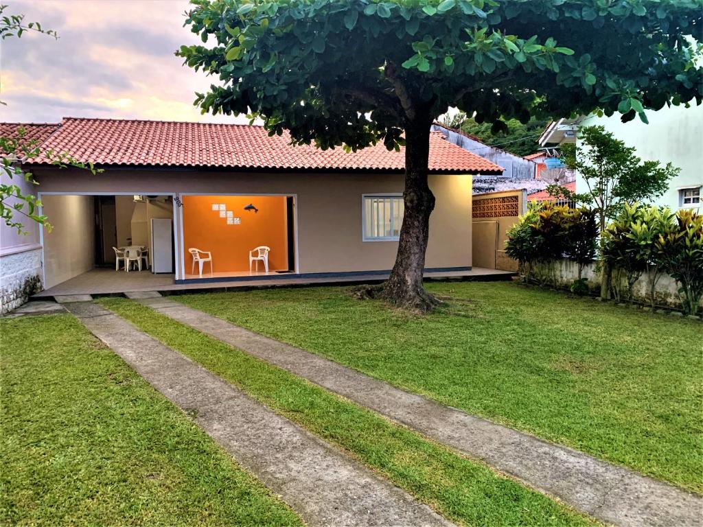 une petite maison avec un arbre dans la cour dans l'établissement Casa Bombinhas, à Bombinhas