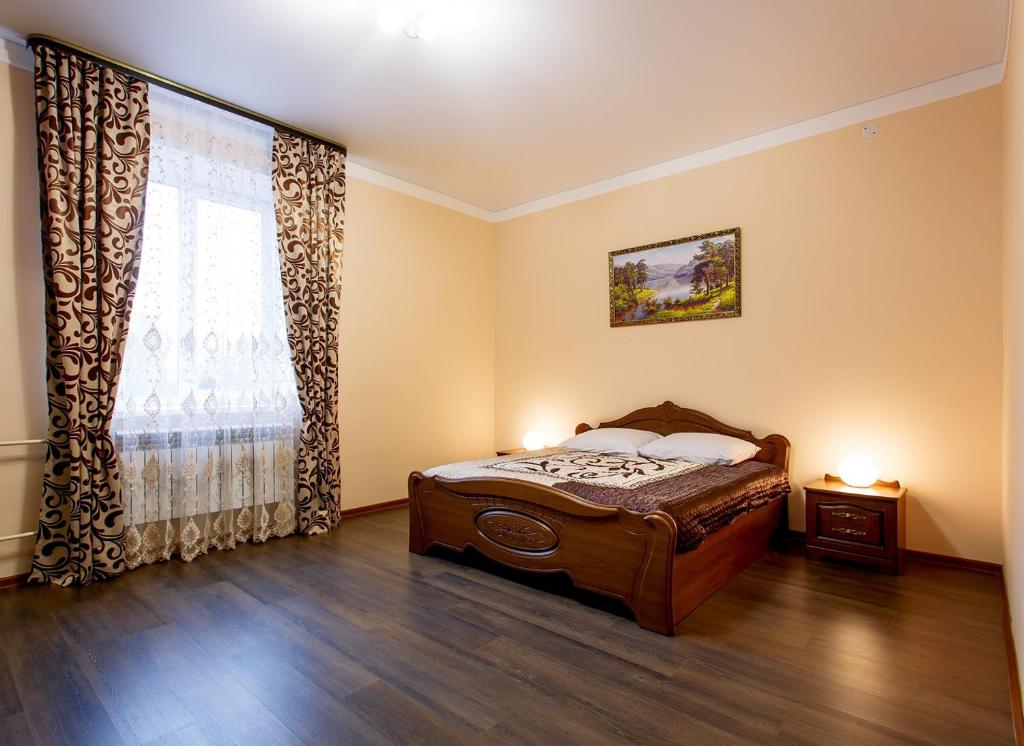 a bedroom with a bed and a large window at Korona Hotel in Yoshkar-Ola