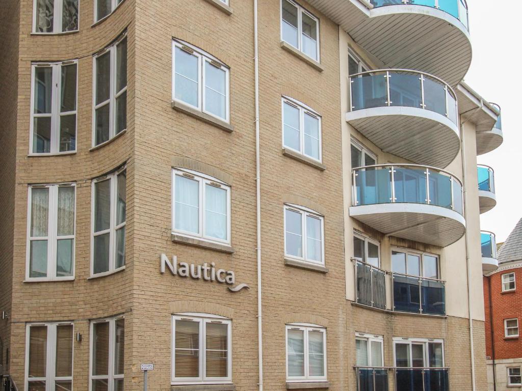 Un edificio con un balcón redondo en el costado. en Nautical Breeze, en Weymouth