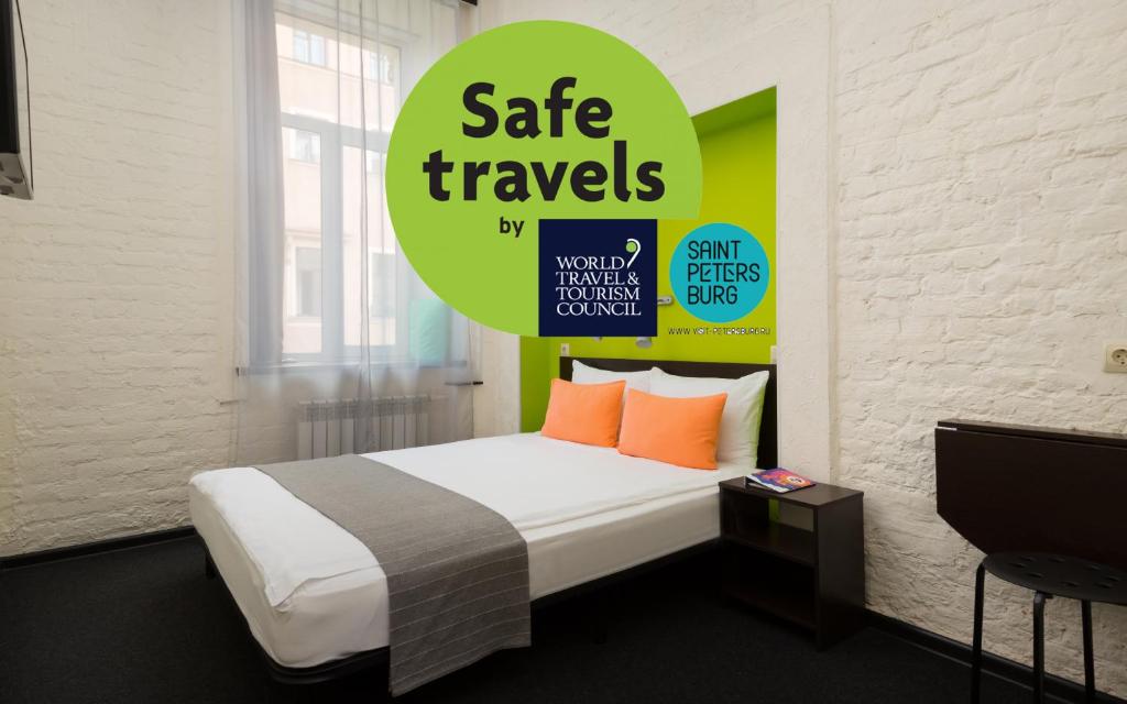 a bedroom with a bed with a sign that reads safe travels at Station Hotel S13 in Saint Petersburg