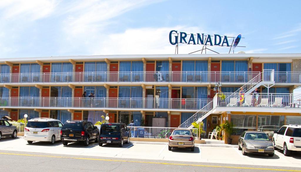 威爾伍德克拉斯特的住宿－格拉納達海洋度假勝地汽車旅館，停车场内停放汽车的大型建筑