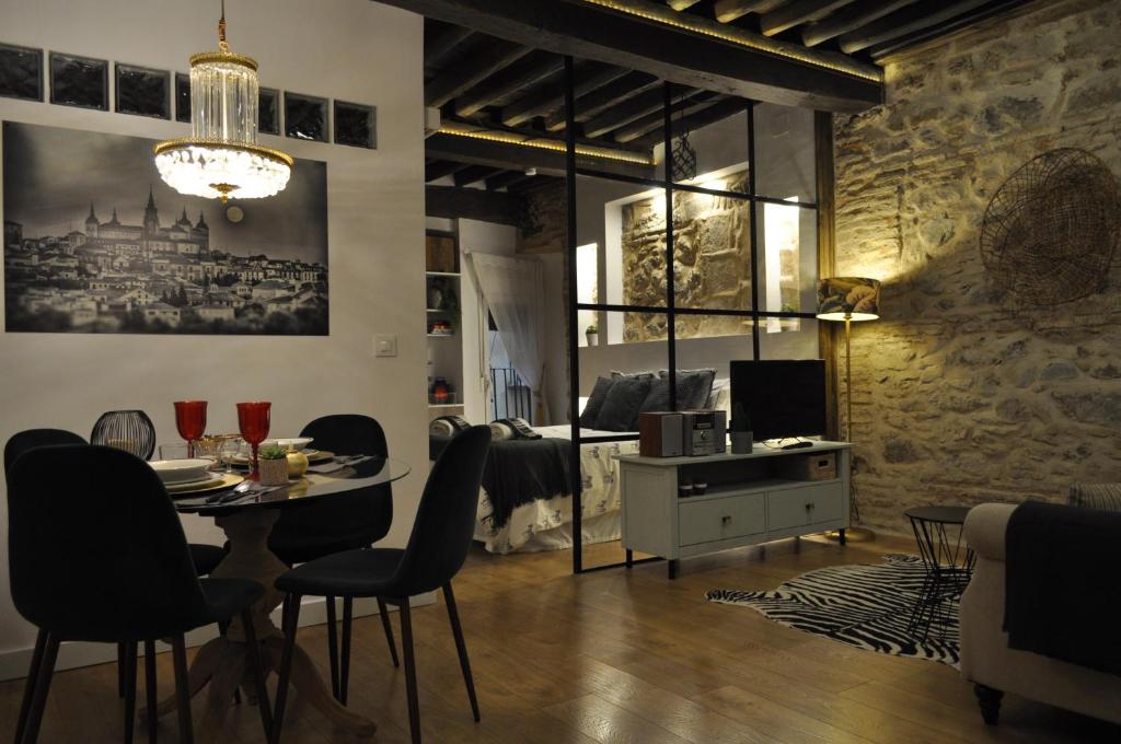 Una sala de estar con mesa y sillas y un comedor. en Lofts amantes de Toledo- LOFT ALCAZAR, en Toledo